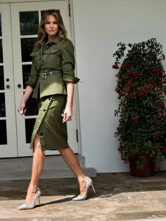 Penampilan Ibu Negara AS, Melania Trump saat menyambut tamu negara di Gedung Putih, Washington, AS, (27/4). Sambut kedatangan Presiden Argentina Mauricio Macri dan istrinya Juliana Awada, Melania tampil dengan busana army. (AFP Photo/Jim Watson)
