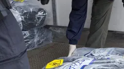 Polisi federal memindahkan paket kokain yang berhasil disita dari sebuah yacht di Sydney, Senin (6/2). Penyitaan kokain lebih dari 1 ton ini merupakan yang terbesar ditemukan dalam operasi narkoba oleh Australia. (STR/Australian Federal Police/AFP)