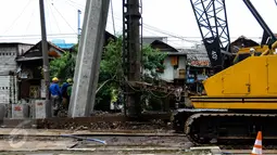 Pekerja dibantu alat berat menggarap pemasangan turap di kawasan Kali Roxy, Jakarta, Senin (14/11). Pemasangan dinding turap tersebut guna mengantisipasi luapan air kali saat musim penghujan. (Liputan6.com/Faizal Fanani)