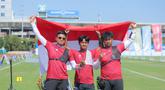 Tim panahan Indonesia, Riau Ega Agata Salsabilla, Ahmad Khoirul Baasith dan Arif Dwi Pangestu (kiri ke kanan) memegang bendera Merah Putih usai memenangi nomor recurve beregu putra SEA Games 2025 di Football Field 1, Bangkok, Thailand, Rabu (17/12/2025). Indonesia kembali menambah koleksi raihan medali emas SEA Games 2025 Thailand. (Bola.com/Bagaskara Lazuardi)