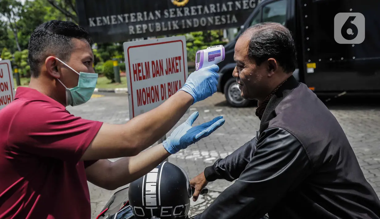 Petugas memeriksa suhu tubuh seorang pria saat akan memasuki Kompleks Istana Kepresidenan, Jakarta, Selasa (3/3/2020). Istana Kepresidenan memperketat pemeriksaan terhadap tamu, ASN, dan pejabat negara untuk mencegah penyebaran virus corona (COVID-19). (Liputan6.com/Faizal Fanani)