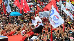 Capres 01 Joko Widodo berselfie dengan pendukungnya saat kampanye terbuka di Banyumas, Jawa Tengah, Kamis (4/4). Dalam kampanye tersebut Jokowi mengajak para pendukung untuk memerangi hoax dan memenangkan pasangan no urut 01 Jokowi-ma'ruf di banyumas.(Liputan6.com/Angga Yuniar)