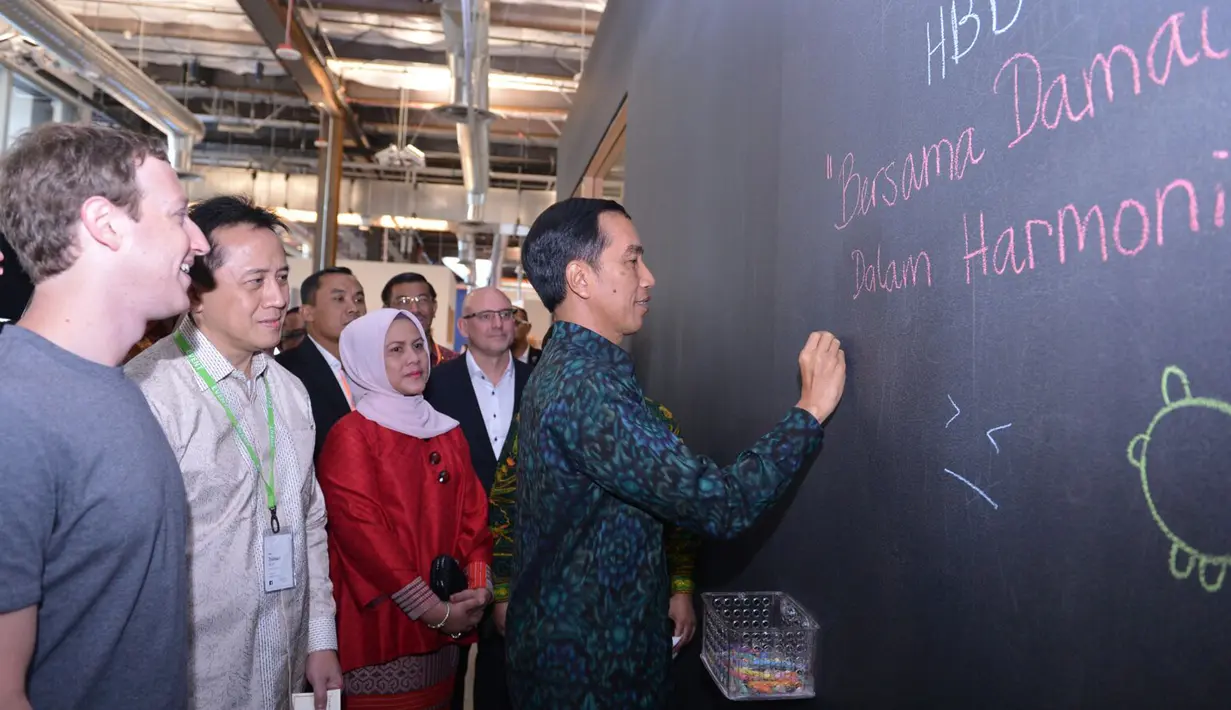 Presiden Jokowi ditemani Mark Zuckerberg, membubuhkan pesan serta tanda tangan di dinding saat berkunjung ke kantor Facebook di Silicon Valley, San Fransisco, Rabu (17/2). Pesan tersebut bertuliskan "Bersama Damai dalam Harmoni". (Setpres/Biro Pers)