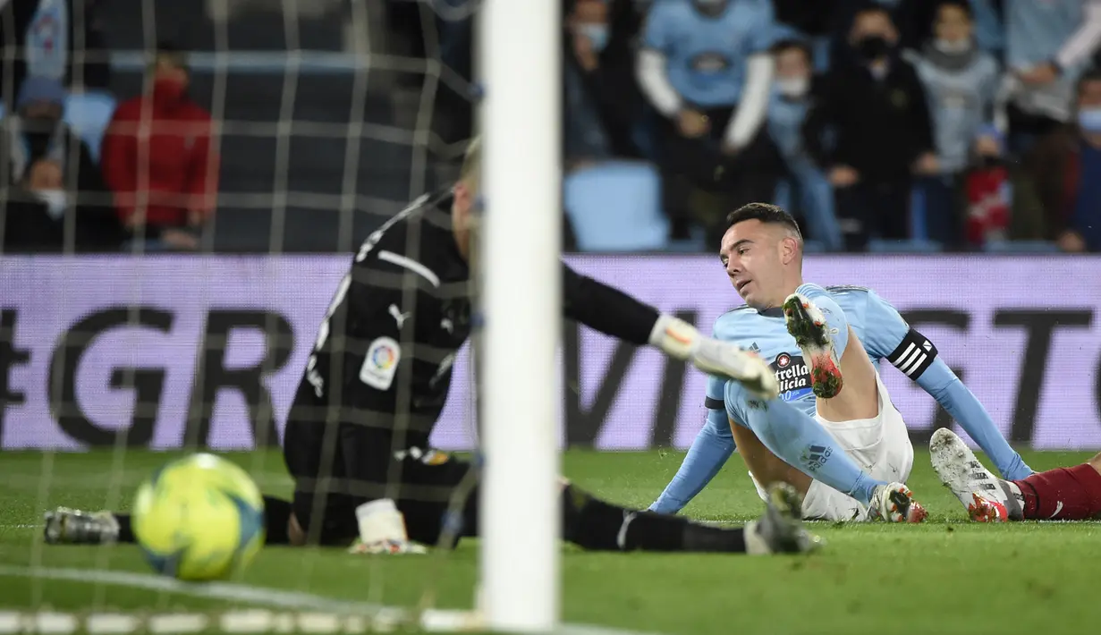 Pemain Celta Vigo Iago Aspas (kanan) mencetak gol melewati kiper Valencia Jasper Cillessen pada pertandingan Liga Spanyol di Stadion Balaidos, Vigo, Spanyol, 5 Desember 2021. Valencia menang 2-1. (MIGUEL RIOPA/AFP)