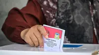 Sejak pertama kali diperkenalkan, Pilkada telah menjadi sarana untuk memilih pemimpin daerah yang diharapkan berkualitas. Tampak dalam foto, pemilih memasukkan surat suaranya dalam pemilihan kepala daerah di Darul Imarah, pinggiran Banda Aceh pada 27 November 2024. (CHAIDEER MAHYUDDIN/AFP)