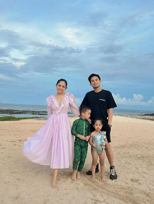 Potret liburan dengan outfit kompak dari keluarga Rachel Vennya dan Okin. Rachel tampil cantik dengan dress beraksen ruffles berwarna ungu muda yang super cantik, Okin kembali dengan kaus dan celana pendek hitam. Sedangkan dua buah hatinya kompak mengenakan swimsuit bernuansa hijau yang menggemaskan. Foto: Instagram.