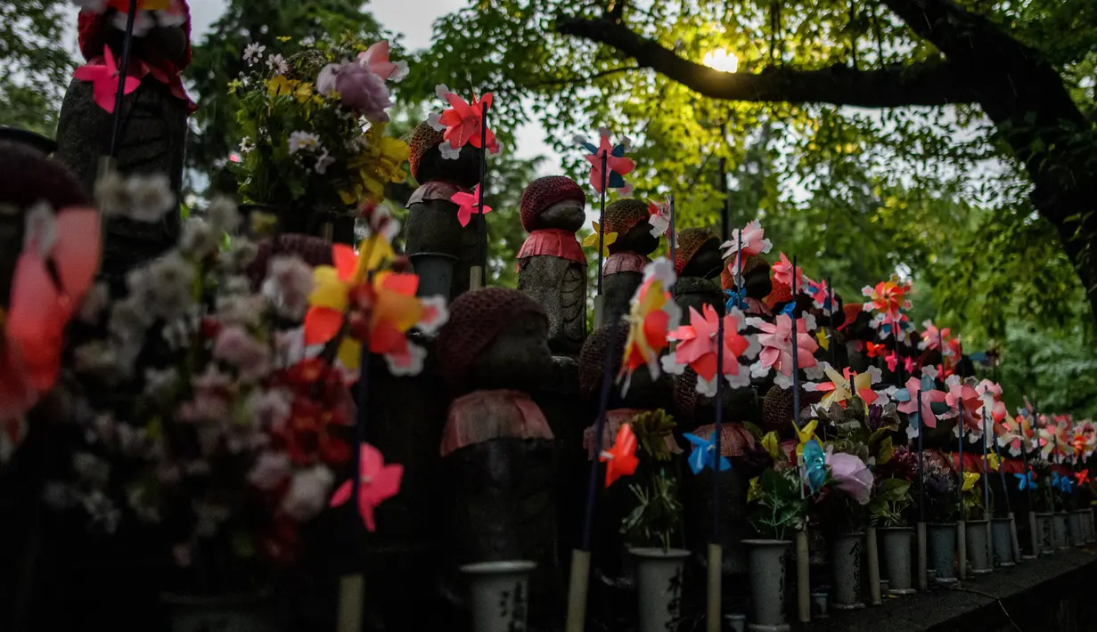 Patung-patung Jizo terlihat di Kuil Zojoji, Tokyo pada 22 Juni 2020. Jizo adalah pelindung dari anak-anak yang belum sempat lahir atau meninggal dalam kandungan dan saat masih bayi. (Photo by Philip FONG / AFP)
