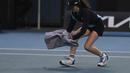 Seorang ball girl berusaha menangkap seekor serangga yang memasuki lapangan menggunakan handuk ketika laga Australia Open 2024 antara petenis Inggris, Emma Raducanu melawan petenis Amerika Serikat di Melbourne Park, Melbourne, Australia, Selasa (16/01/2024). (AP Photo/Louise Delmotte)