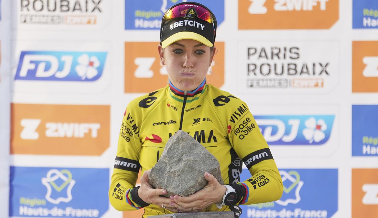 Ekspresi keberatan pembalap Team Visma-Lease, Pauline Ferrand-Prevot saat menjunjung trofi kemenangan Paris Roubaix Femmes 2025 pada Sabtu (12/04/2025) waktu setempat. Perlombaan tersebut menempuh 148,5 km dari Denain hingga Roubaix, Prancis. (AP Photo/Thibault Camus)
