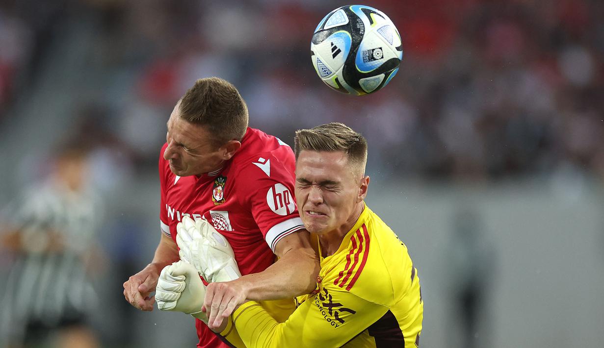 Pemain Wrexham, Paul Mullin (kiri) berebut bola dengan kiper Manchester United, Nathan Bishop pada laga uji coba pramusim di Snapdragon Stadium, San Diego, California, Rabu (25/07/2023) WIB. (AFP/Getty Images/Sean M. Haffey)