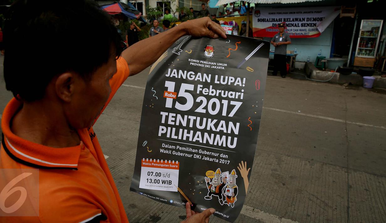 Seorang warga membaca poster yang dibagikan oleh KPU saat sosialisasi Pilkada DKI 2017 di Terminal Senen, Jakarta, Minggu (18/12). Sosialisasi pesta demokrasi ini guna mencegah banyaknya pemilih yang golongan putih atau golput. (Liputan6.com/Johan Tallo)