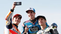 Pembalap MotoGP Marc Marquez (kiri) bersama pembalap Moto2 Alex Marquez (tengah) dan pembalap Moto3 Lorenzo Dalla Porta (kanan) berswafoto di depan Valencia Motorcycle Grand Prix, Spanyol, Minggu (17/11/2019). Ketiganya sukses merebut gelar juara dunia tahun 2019. (AP Photo/Alberto Saiz)