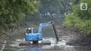 Pekerja mengoperasikan alat berat excavator untuk mengangkat material endapan lumpur di kanal sungai perkantoran Kuningan Jakarta, Rabu (17/2/2021). Pengerukan dilakukan untuk memperlancar aliran air agar tidak terjadi pendangkalan yang mengakibatkan genangan air. (merdeka.com/Imam Buhori)