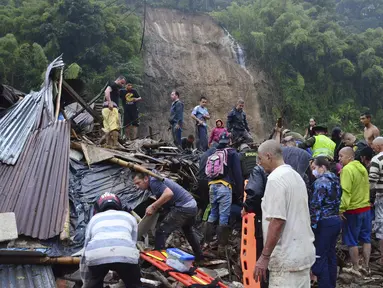 Warga bergabung dengan petugas penyelamat dalam mencari korban selamat setelah lereng bukit yang diguyur hujan runtuh menimpa rumah-rumah di Pereira, Kolombia, Selasa (8/2/2022). Sedikitnya 14 orang tewas dan melukai 35 lainnya akibat musibah tersebut. (AP Photo/Andres Otalvaro)