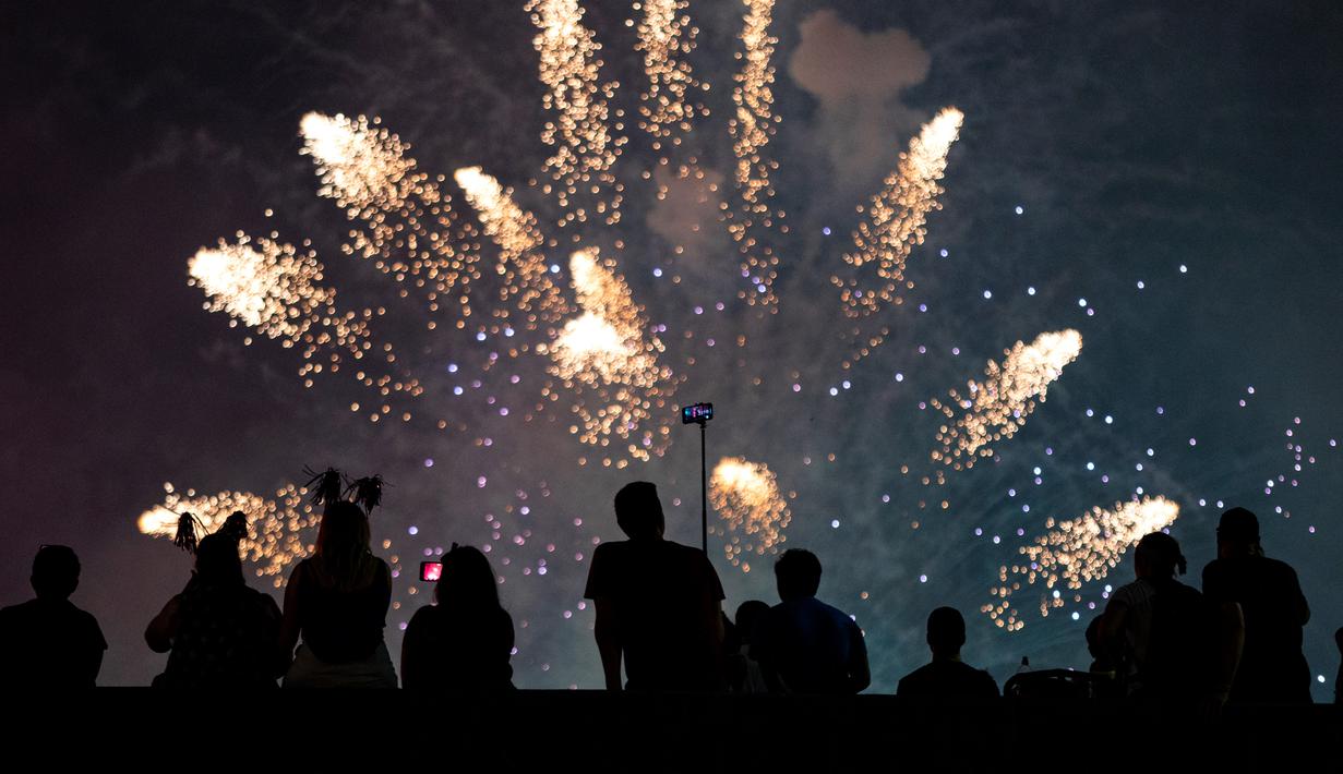 Warga menyaksikan pertunjukan kembang api pada perayaan Hari Kemerdekaan Amerika Serikat di sisi timur Manhattan, Rabu (4/7).  AS merayakan hari kemerdekaan yang jatuh pada 4 Juli atau dikenal sebagai Independence Day 4th July. (AP/Craig Ruttle)