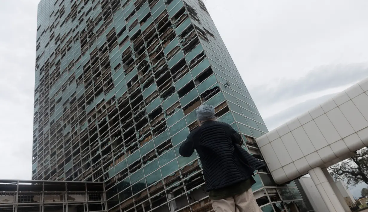 Capitol One Bank Tower terlihat dengan jendelanya yang pecah di pusat kota setelah Badai Laura mendarat di kota pesisir Cameron, Louisiana, AS, Kamis (27/8/2020). Laura merupakan badai tingkat empat yang masuk kategori monster. (ANDREW CABALLERO-REYNOLDS/AFP)