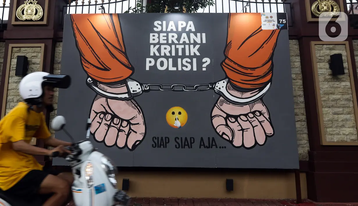 Warga melintas di depan mural berisi kritik terhadap kinerja polisi di Lapangan Bhayangkara Mabes Polri, Jakarta, Minggu (31/10/2021). Sejumlah mural berisi kritik terhadap polisi dipamerkan usai mengikuti ajang Mural Festival 2021 Piala Kapolri 2021. (Liputan6.com/Helmi Fithriansyah)