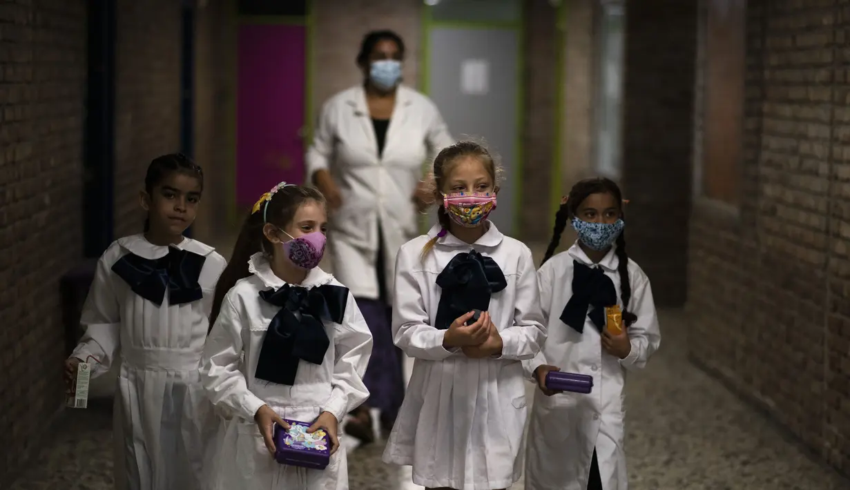 Siswa meninggalkan kelas untuk istirahat pada hari pertama kembali ke kelas tatap muka di tengah pandemi COVID-19 di sekolah umum di Montevideo, Uruguay, Senin (1/3/2021).  Uruguay mengembalikan sebagian besar siswanya ke kelas tatap muka setelah liburan musim panas. (AP Photo/Matilde Campodonico)