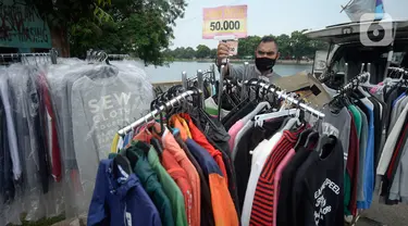 Ridwan (40) menata baju seken (baju bekas) impor di Pamulang, Tangerang Selatan, Banten, Senin (29/9/2020). Sebelumnya Ridwan merupakan pengusaha alat sewa pesta, karena kondisi pandemi Covid-19 sepi hajatan iya beralih menjual baju bekas demi memenuhi kebutuhan sehari-hari. (merdeka.com/Dwi Narwoko