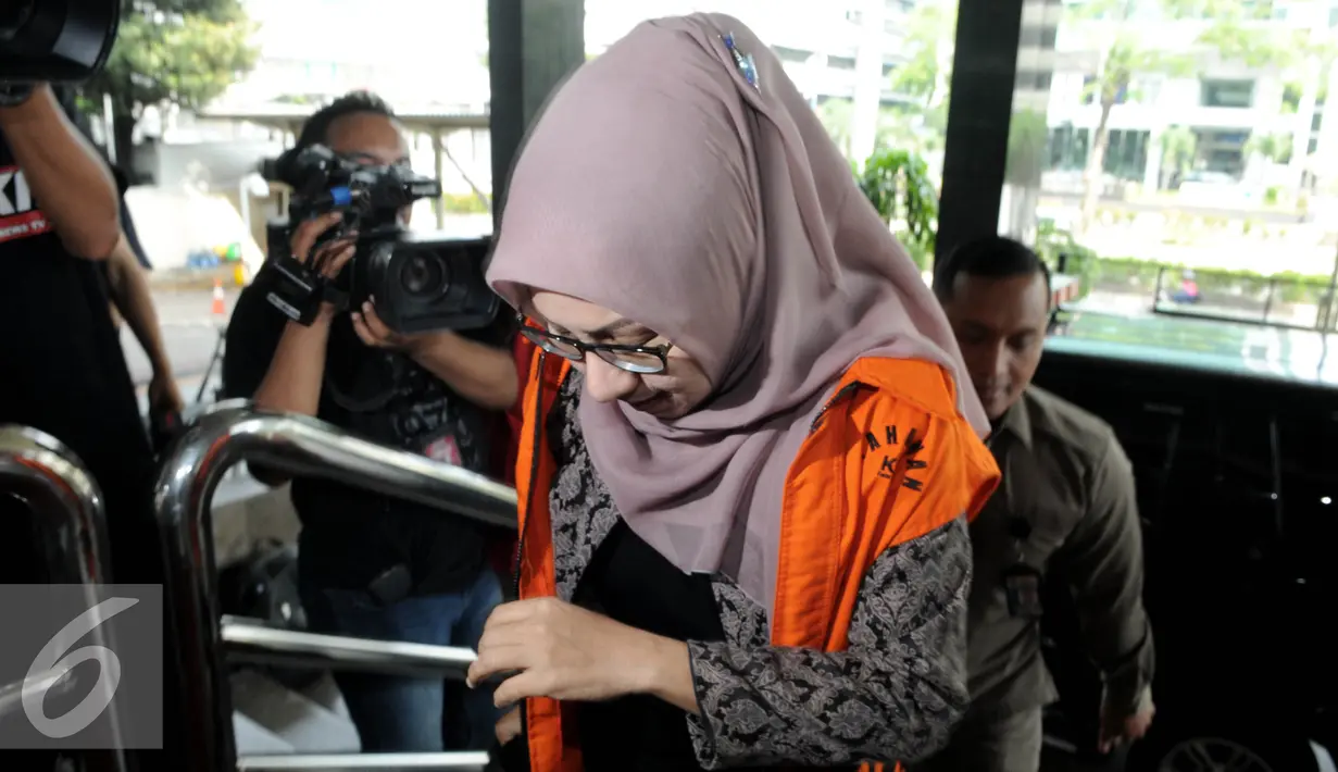 Siti Marwa tertunduk saat berjalan masuk ke dalam gedung KPK, Jakarta, Selasa (12/7). Siti diperiksa terkait penerimaan uang suap Rp1 miliar dari beberapa perusahaan pupuk yang ingin mendapatkan proyek di perusahaan BUMN. (Liputan6.com/Helmi Afandi)