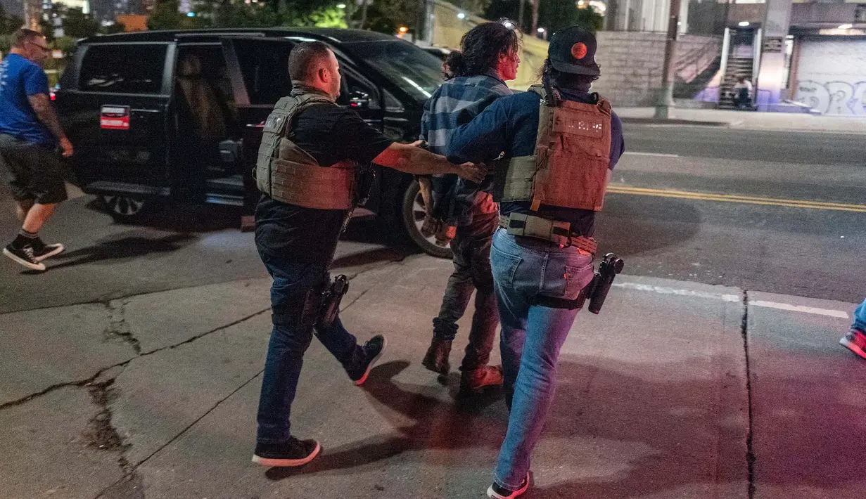 Tak lama setelah aturan diberlakukan, polisi melakukan penangkapan massal. Menurut keterangan aparat keamanan setempat, sejak jam malam berlaku mereka telah menangkap 197 orang. (RINGO CHIU/AFP)