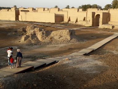 Orang-orang mengunjungi situs arkeologi Babilonia, Irak, Minggu (21/3/2021). Komite Warisan Dunia UNESCO telah menetapkan kota kuno Babilonia di Mesopotamia sebagai Situs Warisan Dunia. (AP Photo/Hadi Mizban)