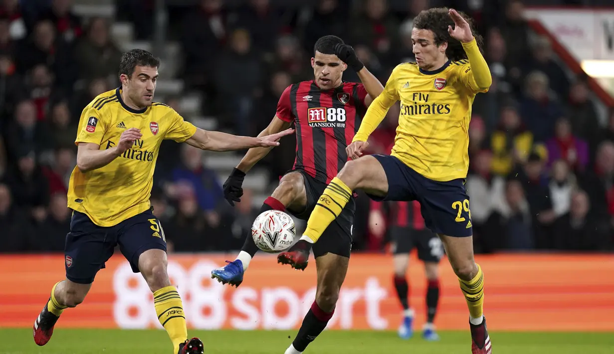 Striker Bournemouth, Dominic Solanke (tengah) berebut bola dengan dua pemain Arsenal, Sokratis Papastathopoulos dan Matteo Guendouzi pada pertandingan putaran keempat Piala FA di Stadion Vitalitas, Inggris (27/1/2020).  Arsenal berhasil melaju ke babak kelima Piala FA. (John Walton/PA via AP)