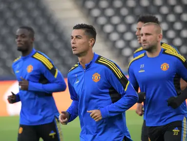 Penyerang Manchester United, Christiano Ronaldo (tengah) bersama rekan satu timnya melakukan pemanasan dalam sesi latihan di Bern (13/9/2021). Manchester United akan bertanding melawan Young Boys pada Grup F Liga Champions di Stadion Wankdorf. (AFP/Sebastien Bozon)