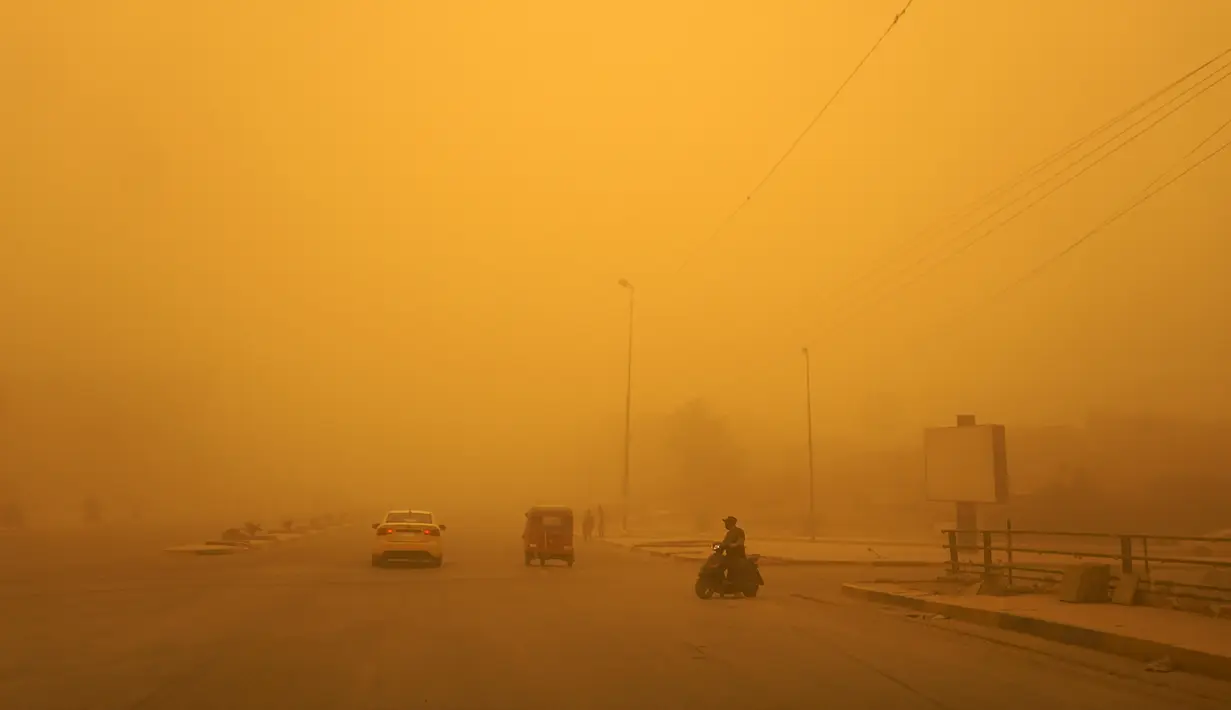 Kendaraan melaju di sepanjang jalan saat badai debu berat menghantam Baghdad, Irak, Senin (16/5/2022). (Sabah ARAR/AFP)