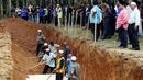 Warga membantu proses pemakaman massal jenazah yang di duga etnis Rohingya di Alor Setar, Malaysia, Senin (22/6/2015).  21 dari 106 jenazah tak dikenal yang ditemukan bulan lalu dimakamkan hari ini. (Reuters/Olivia Harris)