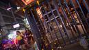Foto pada 11 Oktober 2018 memperlihatkan wanita berjalan melewati sebuah bar di Nana Red Light Distrik, Bangkok, Thailand. Kawasan tersebut merupakan tempat lokalisasi hiburan malam paling tersohor di Bangkok. (Romeo GACAD / AFP)