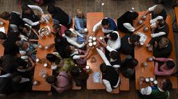 Pengunjung menikmati bir selama Festival Oktoberfest 2019 di sebuah tenda di Munich, Jerman selatan (3/10/2019). Festival bir terbesar di dunia Oktoberfest berlangsung hingga 6 Oktober 2019. (AFP Photo/Christof Stache)