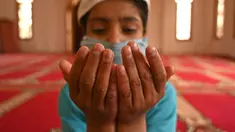 Seorang anak yatim Muslim mengenakan masker berdoa sambil menjaga jarak sosial di dalam pusat panti asuhan selama bulan suci Ramadan di Srinagar (11/5/2020). (AFP/Tauseff Mustafa)