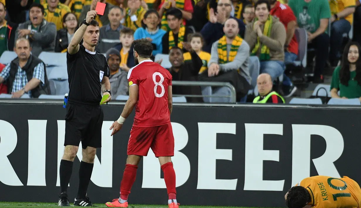 Wasit, Ravshan Irmatov (kiri) memberkan kartu merah kepada pemain Suriah, Mahmoud Al Mawas (tengah) pada laga kualifikasi Piala Dunia 2018 di  Sydney (10/10/2017). Australia menang 2-1 pada leg kedua tersebut. (AFP/Saeed Khan)