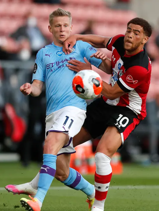 Bek Manchester City, Oleksandr Zinchenko berebut bola dengan pemain Southampton Che Adams dalam lanjutan Liga Inggris di St. Mary Stadium, Minggu (5/7/2020).  Manchester City gagal memetik poin penuh setelah kalah tipis 0-1 saat bertandang ke markas Southamtpon. (AP Photo/Frank Augstein, Pool)