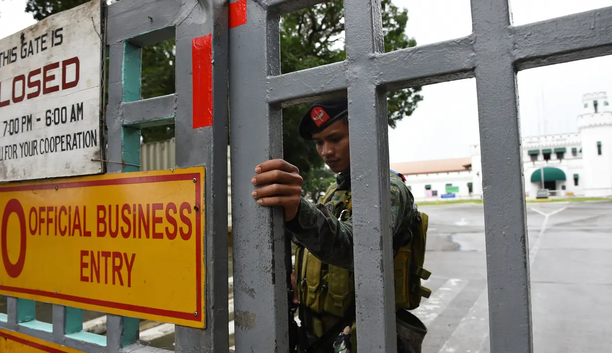 Polisi pasukan khusus berdiri di gerbang sebuah penjara di Filipina usai insiden kerusuhan, Rabu (28/9). Satu anggota geng narkoba tewas dan tiga napi terluka dalam kerusuhan di penjara yang terkenal dengan kekerasan dan kekejamannya. (TED Aljibe/AFP)