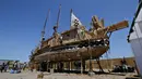 Sejumlah orang melihat dan menaiki perahu Viracocha III yang sedang bersandar di Pantai Chinchorro di kota Arica, Chili (5/2). Perahu unik yang terbuat dari rumput totora merupakan perahu tradisional Suku Aymara di Bolivia. (AFP Photo/Ignacio Munoz)