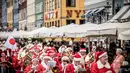 Santa claus mengikuti pawai yang merupakan bagian dari Kongres Dunia Sinterklas di Kopenhagen, Denmark, Senin (23/7). Kegiatan sejak 1957  itu merupakan forum pertemuan nyata ratusan santa dari seluruh dunia. (Mads Claus Rasmussen/Ritzau Scanpix /AFP)