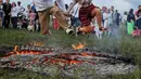 Warga melompati api unggun saat perayaan tradisional Ivan Kupala di Kiev, Ukraina, Rabu (6/7). Ivan's day merupakan tradisi pagan kuno sebagai ritual kesuburan di musim panas yang masih ada di Rusia dan Ukraina. (REUTERS/ Gleb Garanich)