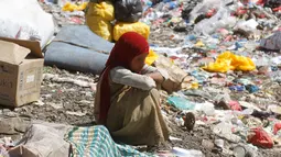 Bocah perempuan duduk di antara tumpukan sampah di sebuah tempat pembuangan akhir (TPA) di pinggiran Sanaa, Yaman, Rabu (16/11). Setiap hari para bocah di daerah tersebut mengumpulkan sampah untuk didaur ulang. (REUTERS/Mohamed al-Sayaghi)