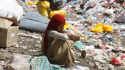 Bocah perempuan duduk di antara tumpukan sampah di sebuah tempat pembuangan akhir (TPA) di pinggiran Sanaa, Yaman, Rabu (16/11). Setiap hari para bocah di daerah tersebut mengumpulkan sampah untuk didaur ulang. (REUTERS/Mohamed al-Sayaghi)