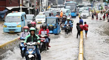 Pengendara menerobos genangan air di sebagian ruas Jalan Jatinegara Barat, Jakarta, Rabu Rabu (1/1/2020). Hujan yang mengguyur Jakarta sejak Selasa sore (31/12/2019) mengakibatkan banjir di sejumlah titik di Jakarta. (Liputan6.com/Helmi Fithriansyah)