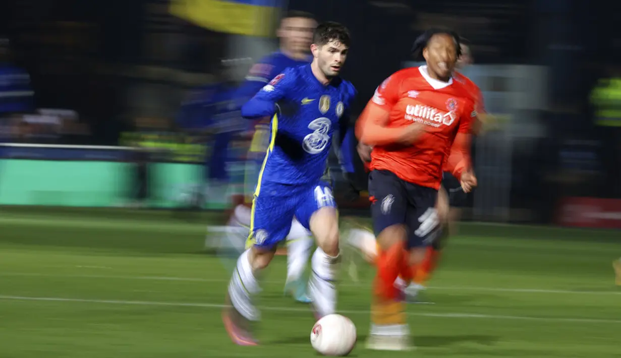 Dalam foto yang diambil dengan kecepatan rana lambat menunjukkan pemain Chelsea Christian Pulisic (kiri) berlari dengan bola saat melawan Luton Town pada pertandingan sepak bola putaran kelima Piala FA di Kenilworth Road, Luton, Inggris, 2 Maret 2022. Chelsea menang 3-2. (AP Photo/Ian Walton)
