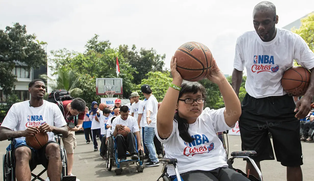Perwakilan NBA Asia, Chris Sumner, menyemangati seorang penyandang disabilitas untuk melempar bola. (Bola.com/Vitalis Yogi Trisna)