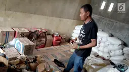 Seorang pria memeriksa barang bukti minuman keras Cap Tikus di Polres Gorontalo, Kamis, (24/1). Sebanyak 1,5 ton Cap Tikus dalam kantong plastik diselundupakan dalam karung. (Liputan6.com/Arfandi Ibrahim)