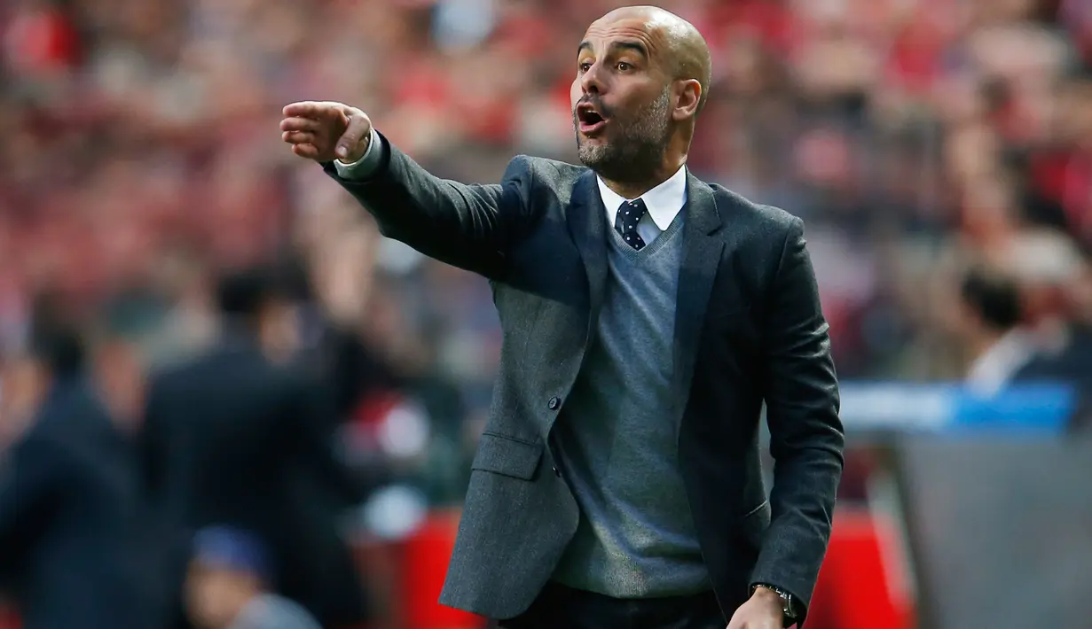 Pelatih Muenchen, Josep Guardiola mengintruksikan pemainnya saat melawan Benfica di leg kedua Liga Champions di Stadion Da Luz, Portugal (14/4). Muenchen berhak lolos ke semifinal usai  menahan imbang Benfica dengan skor 2-2. (Reuters/Rafael Marchante)