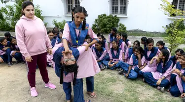 Dua siswi saat belajar bela diri di Telangana Minorities Residential Girls School di Hyderabad, India (17/6/2019). Maraknya kejahatan, kekerasan dan pelecehan seksual yang terjadi terhadap perempuan India membuat pelajaran bela diri diadakan di sekolah. (AFP Photo/Noah Seelam)