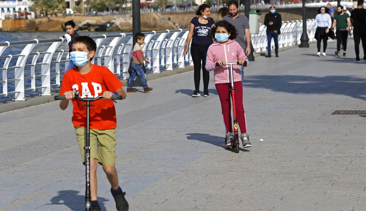 Anak-anak bermain otopet dengan memakai masker di Beirut, Lebanon, 3 Mei 2020. Lebanon telah mengurangi langkah-langkah mobilisasi umum dengan mengizinkan restoran untuk melayani sejumlah kecil pelanggan mulai 4 Mei dan menerapkan jam operasional untuk sektor-sektor lainnya. (Xinhua/Bilal Jawich)