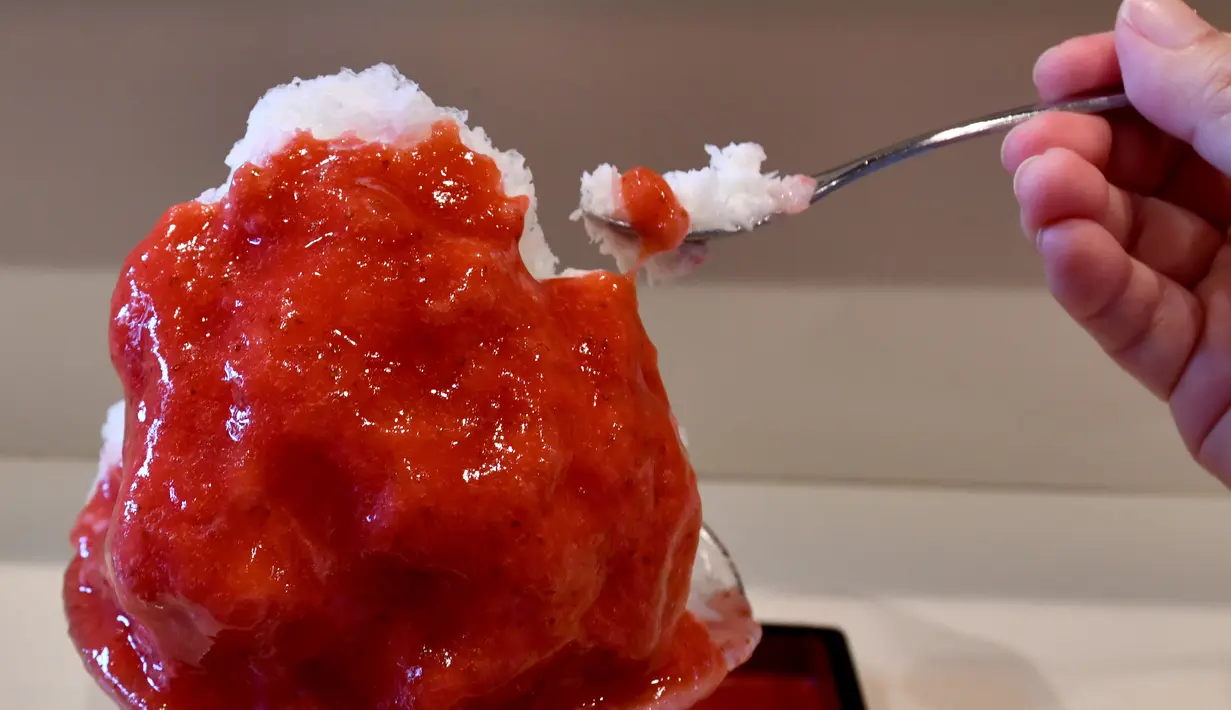 Pemilik toko Koji Morinishi membuat sajian kakigori atau es serut di distrik Yanaka Tokyo, Jepang (21/6/2019). Kakigori atau es serut ini menggunakan es alami yang dibuat langsung dari pegunungan di utara Tokyo, Yuichiro Yamamoto. (AFP Photo/Toshifumi Kitamura)