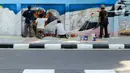 Suasana saat sejumlah seniman membuat mural bertema biota laut pada dinding di kawasan Cideng, Jakarta, Rabu (29/11/2023). Mural dibuat guna memperindah sekaligus penataan kawasan Kelurahan Cideng, Jakarta Pusat. (Liputan6.com/Herman Zakharia)